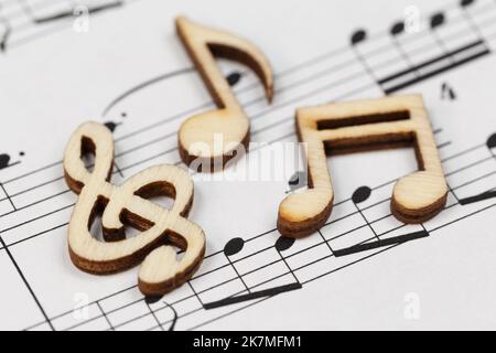 Wooden notes lie on a sheet of music. Close-up. Stock Photo