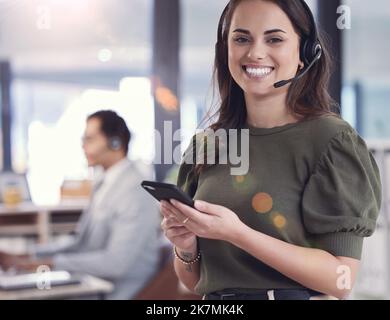 Customer care is my passion. a young female call center agent using a phone at work. Stock Photo