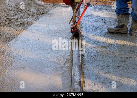 This machine is used to align fresh concrete compacted layer on new driveway that is being constructed Stock Photo