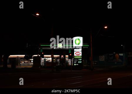 Suburban BP service station and IGA Xpress at night, with brightly illuminated signs, seen from across an intersection Stock Photo