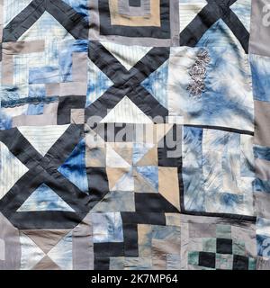 part of hand-crafted patchwork quilt from pieces of various silk fabrics sewn in convergence technique Stock Photo