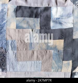 detail of hand-crafted patchwork quilt from pieces of various silk fabrics sewn in convergence technique Stock Photo