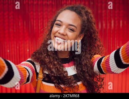 Face, selfie and smile with a black woman happy against a red background while taking a photograph. Social media, fashion and beauty with an Stock Photo