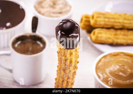 Churros, fried candy filled with creamy chocolate, covered in sugar, tradition at popular parties or breakfast Stock Photo