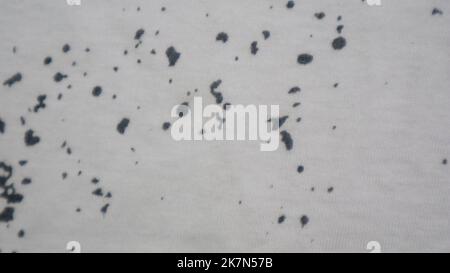 White cloth texture with black spots as background Stock Photo