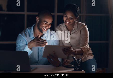 Have you seen this. a young couple using a digital tablet together at night. Stock Photo