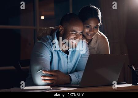 Youre doing great things for us. a young woman checking in on her husband as he works on his laptop. Stock Photo