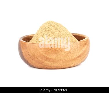 Wooden bowl with ground ginger root powder on a white background. Copy space. Stock Photo