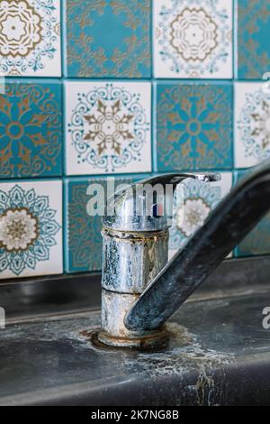 Old rusty sink faucet in kitchen. Rust streaks, calcium scale, hard water. Concept of poor water quality. Stock Photo