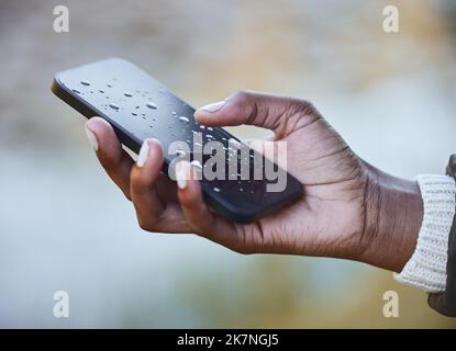 Water damage is so costly to repair. a woman holding a wet phone during a camping trip. Stock Photo