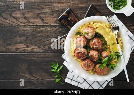 Swedish meatballs in cream sauce, potatoes and lingonberry sauce in bowl on old wooden rustic backgrounds. Swedish cuisine. Delicious creamy mashed po Stock Photo
