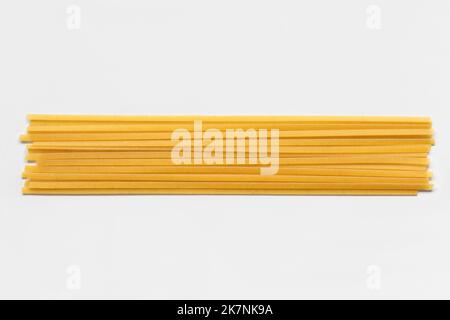 Durum fettuccine pasta on white background. Raw spaghetti or noodles Stock Photo