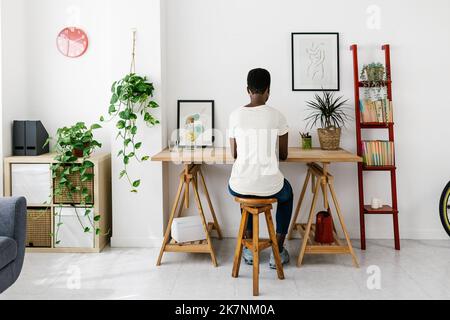 Creative young african woman working on laptop at home studio office Stock Photo