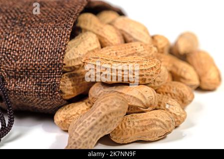 Peanuts in a jute bag against a white background Stock Photo