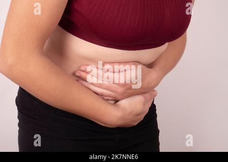 abdominal pain concept, woman hands  holding her stomach. Stock Photo