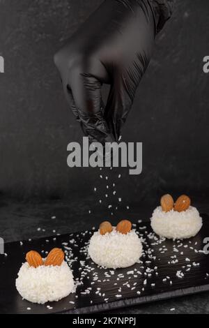 delicious dessert creamy souffle decorated with coconut chips and nuts on a dark background Stock Photo