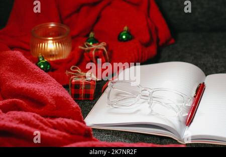 Christmas composition with notebook, pen, glasses, candle and decor Stock Photo