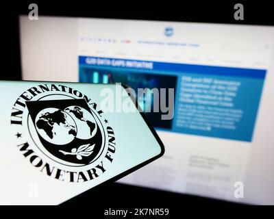 Smartphone with logo of UN agency International Monetary Fund (IMF) on screen in front of website. Focus on center-right of phone display. Stock Photo