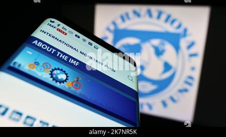 Mobile phone with website of UN agency International Monetary Fund (IMF) on screen in front of logo. Focus on top-left of phone display. Stock Photo