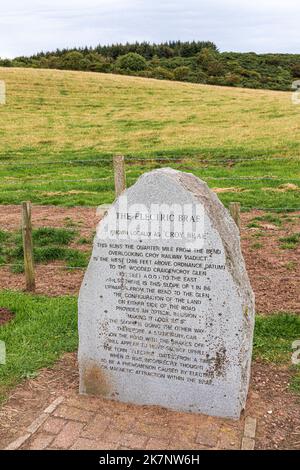 A stone marking Electric Brae or Croy Brae, a road giving an optical illusion of sloping in the wrong direction at Croy, South Ayrshire, Scotland UK Stock Photo