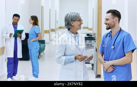 Healthcare doctors making rounds, talking in hospital corridor while working day. hospital treatment Stock Photo