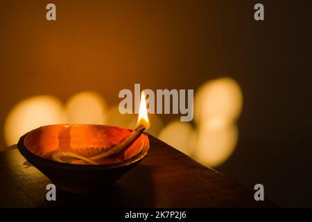 diya or earthen oil lamp lit with flame during diwali celebration in india. deepabali or kali puja is celebrated across india as a major festival of l Stock Photo