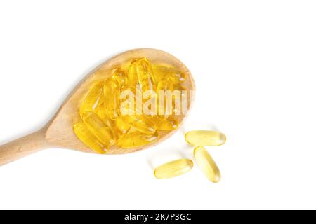 Pile of capsules Omega 3 in wooden spoon isolated on white background. Softgels, tablets for skin, health, disease treatment. Health care, diet, heart Stock Photo