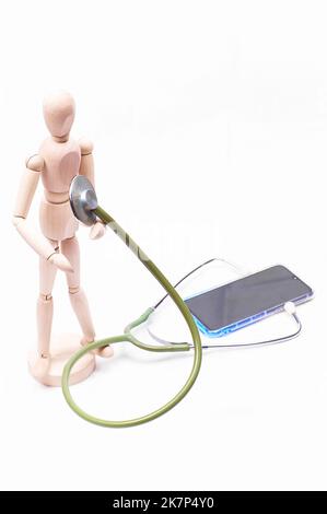 Articulated wooden doll with a stethoscope and a telephone concept of online medical diagnostics Stock Photo