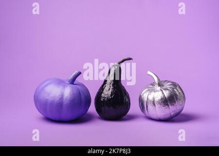 Multi-colored, different pumpkins, on a purple background. The concept of a festive background for Halloween, children's entertainment, crafts and pre Stock Photo