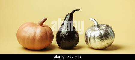 Minimal Harvest background concept, pumpkins of different shapes and colors on a yellow background. The concept of the autumn season, harvest, thanksg Stock Photo