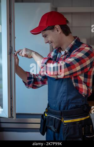 Joyful repairman installing the window in the kitchen Stock Photo