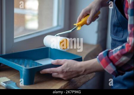 Experienced worker getting ready for painting the window frame Stock Photo