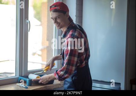 Cheerful worker getting ready for painting work Stock Photo