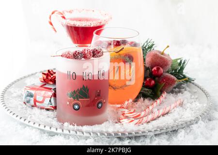 Fresh Christmas cocktails on a metal serving tray against a bright background. Stock Photo