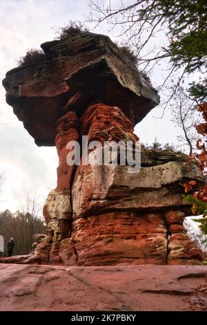 Hinterweidenthal, Germany - January 1, 2021: Red rock formation called Devil's Table in the Palatinate Forest of Germany on a cloudy winter day. Stock Photo