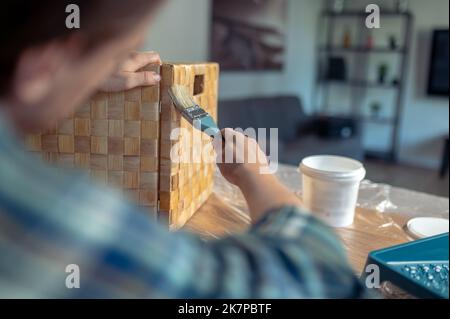 Experienced woodworker involved in painting the outside of the box Stock Photo