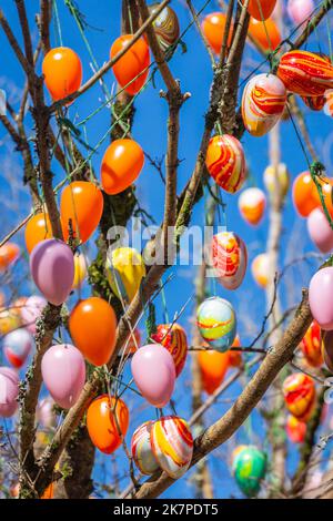 Colorful and handmade easter eggs hanging on apple tree, Gramado, Brazil Stock Photo
