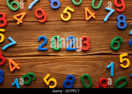 Colored number 2023 on wooden background. 2023 happy new year symbol Stock Photo