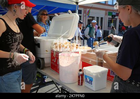 A worker from Gracie's Ice Cream toasts a marshmallow fluff dipped ice cream cone at the What The Fluff Festival in Somerville, Massachusetts Stock Photo