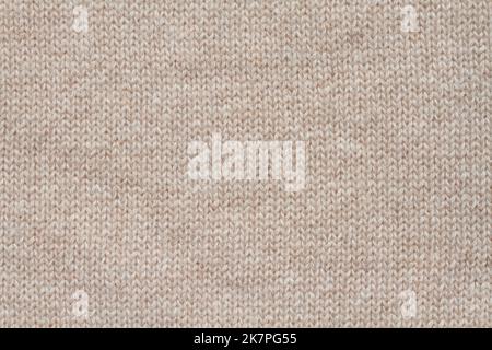 Light beige woolen knitted fabric texture. Macro. Stock Photo