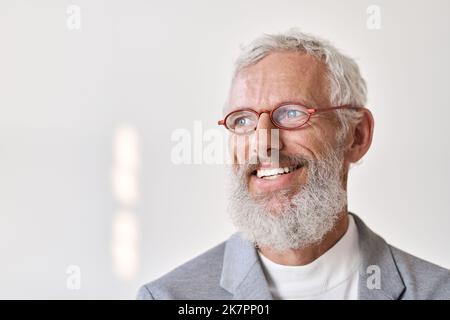 Smiling senior old business man looking away isolated on white wall. Stock Photo