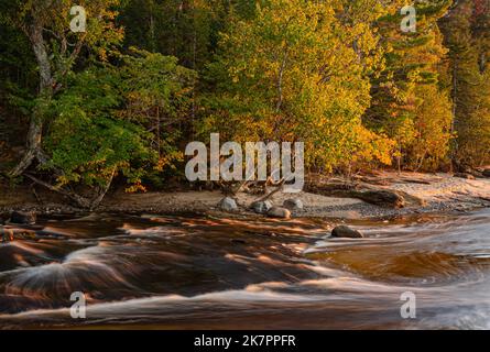 Autumn color change has just started but the Hurricane River is in a hurry to meet Lake Superior, Pictured Rocks National Lakeshore, Alger County, MI Stock Photo