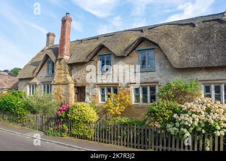 Thatched hamstone cottage, High Street, Hinton St George, Somerset, England, United Kingdom Stock Photo