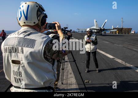 221017-N-MW880-1175 ADRIATIC SEA (Oct. 17, 2022) Royal Navy Cmdr. Grant Kelly, assigned to Allied Joint Force Command Naples, captures video of Alexandra Dinu, Digi24 reporter, aboard the Nimitz-class aircraft carrier USS George H. W. Bush (CVN 77) during the NATO-led vigilance activity Neptune Strike 22.2 (NEST 22.2), in the Adriatic Sea, Oct. 17, 2022. NEST 22.2 is the natural evolution of NATO's ability to integrate the high-end maritime warfare capabilities of a carrier strike group to support the defense of the alliance in Europe. (U.S. Navy photo by Mass Communication Specialist 3rd Clas Stock Photo