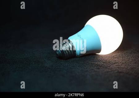Illuminated single unplugged light bulb Stock Photo