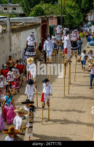 View of people on stilts in the Parade of Delegations to the Guelaguetza in the streets of San Antonino Castillo Velasco near Oaxaca, Mexico. Stock Photo