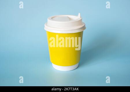 yellow paper coffee mug on a blue background. Empty space for text and design on a cup of coffee. form for the name of the coffee or company or coffee Stock Photo