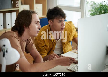College student explaining difficult topic to friend when thay are working on project together Stock Photo