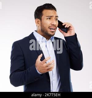 He just received the most frustrating news. Studio shot of a young businessman looking shocked while talking on a cellphone against a white background Stock Photo
