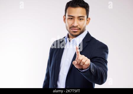 Its easier to navigate the markets this way. Studio shot of a young businessman connecting to a user interface against a white background. Stock Photo